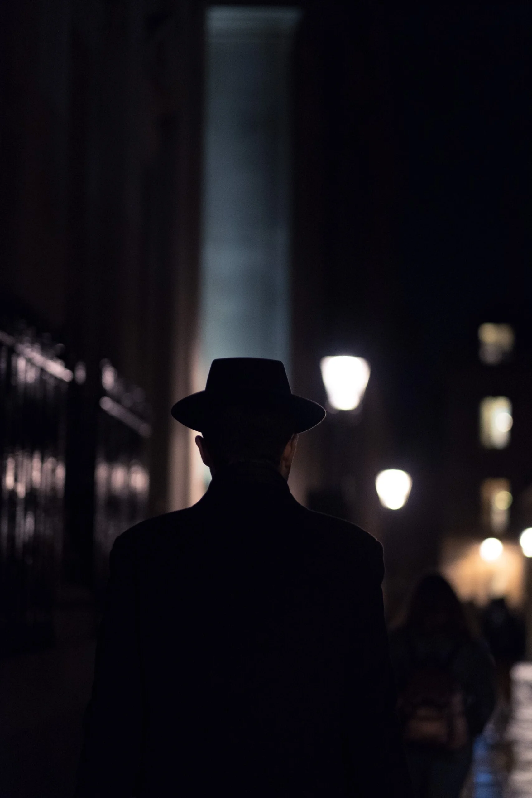 A man in a hat against the background of the night city